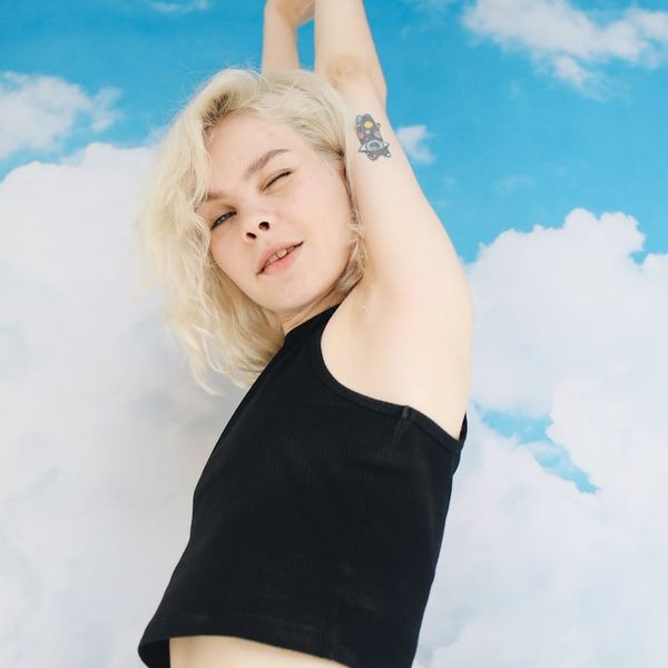 A teenager stretching joyfully against a turquoise background.
